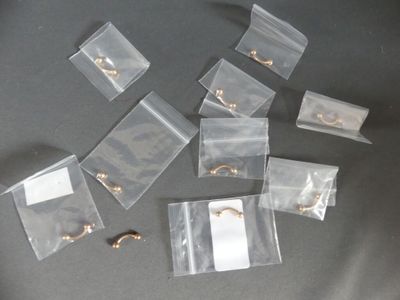 several pieces of clear plastic bags with gold rings on them