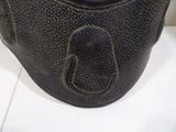 a close up of a black purse on a white surface
