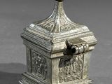 an old silver box with a bird on top of it on a table