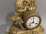 une horloge en or surmontée d'une statue