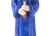 statue d'une femme en robe bleue tenant une croix rouge
