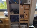 a bookcase with many boxes on it in a room