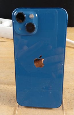 un iPhone bleu posé sur une table en bois
