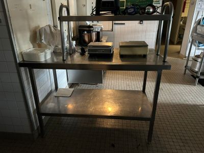 a kitchen with a stainless steel table and a microwave
