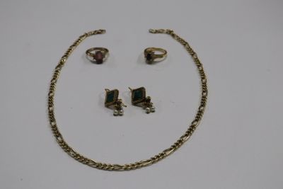 two pieces of jewelry sitting on top of a white surface