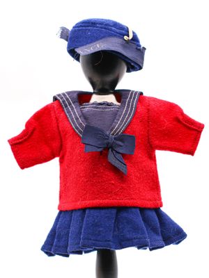 une poupée vêtue d'une robe rouge et bleue et d'un chapeau