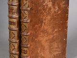 an old book sitting on top of a table next to another book