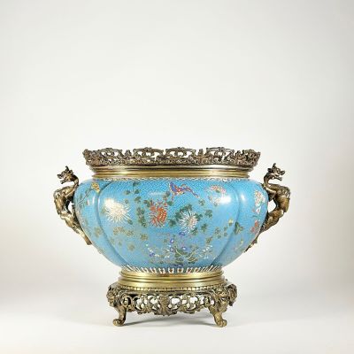 un vase bleu avec un socle doré sur fond blanc