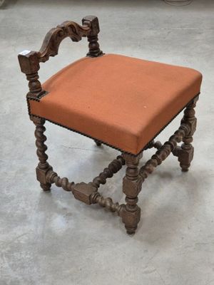 une petite chaise en bois sur laquelle est posé un coussin orange