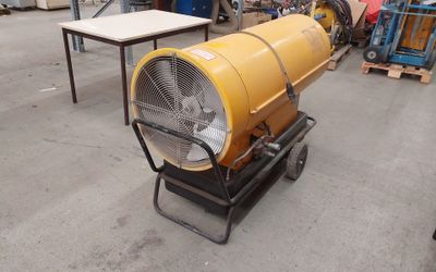 a large yellow blower sitting on a cart in a warehouse