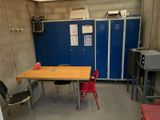 a table and chairs in a room with blue lockers