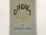 un vieux livre posé sur une table à côté d'un mur blanc