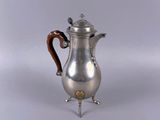 an antique silver coffee pot with a wooden handle on a stand