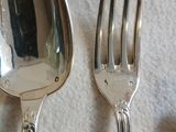 deux cuillères et une fourchette en argent sur une table