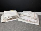 deux sacs en tissu blanc posés par terre l'un à côté de l'autre