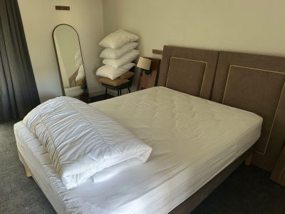 un lit avec des oreillers posés dessus, dans une chambre