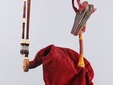 a red bag with a hat and a pair of wooden sticks hanging from it