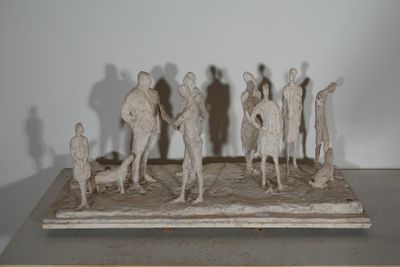 sculpture représentant un groupe de personnes debout sur une table