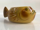 a small ceramic fish that is sitting on a table