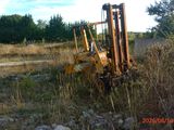 a forklift sitting in the middle of a field