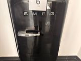 a black refrigerator with a sign on it in a kitchen