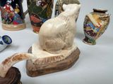 many different vases and a cat statue on a table
