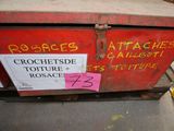 une boîte rouge sur laquelle est écrit quelque chose, posée sur le trottoir
