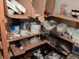 a pantry full of dishes and pans in the corner