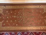 a wooden box with a design on it sitting on a rug