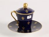 a blue cup and saucer with a gold decoration on it