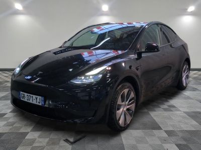 Le SUV Tesla noir est garé sur un sol en carrelage à damier.