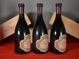 three bottles of wine are sitting on a table with a wooden box
