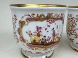 pair of porcelain vases with gold rims decorated with figures and flowers