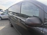 a black van parked in a parking lot with other cars in the background