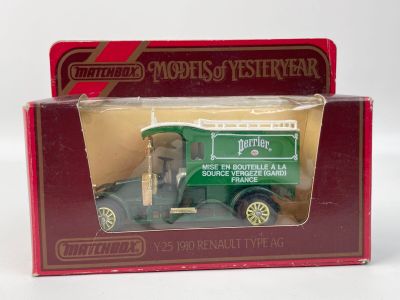 un petit camion vert dans une boîte rouge posée sur une surface blanche