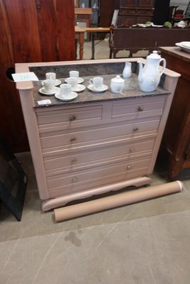 une commode sur laquelle sont posées des tasses et des soucoupes