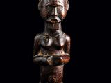 une statue en bois d'un homme avec un chapeau sur la tête