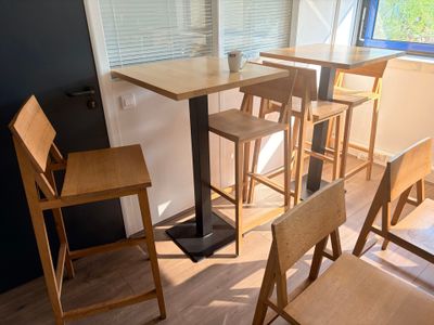 des tables et des chaises dans une pièce dotée d'une fenêtre et d'un parquet