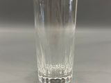a glass of water sitting on a table with a gray background