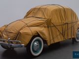 a car covered with a tarp sitting on the floor
