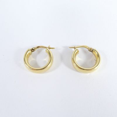 une paire de boucles d'oreilles en or sur fond blanc