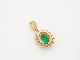 a gold pendant with an emerald stone in the center