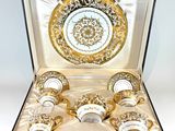 a gold and white cup and saucer set in a box