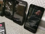 four cell phones are sitting next to each other on the floor