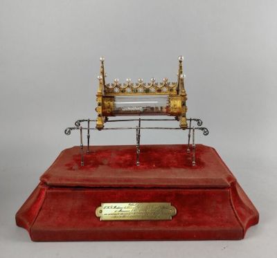 a red box with a gold and silver clock on top of it