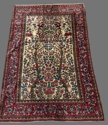 un tapis persan ancien orné d'un motif floral sur fond blanc
