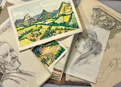 a pile of drawings on a table next to a laptop