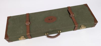 une valise verte avec une poignée marron sur un fond blanc