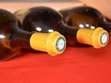 three bottles of wine are lined up on a red cloth