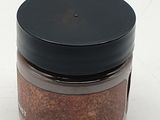 a small jar of spices sitting on a white surface